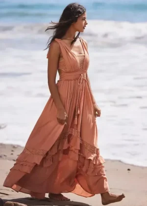 une femme en robe longue marchant sur la plage